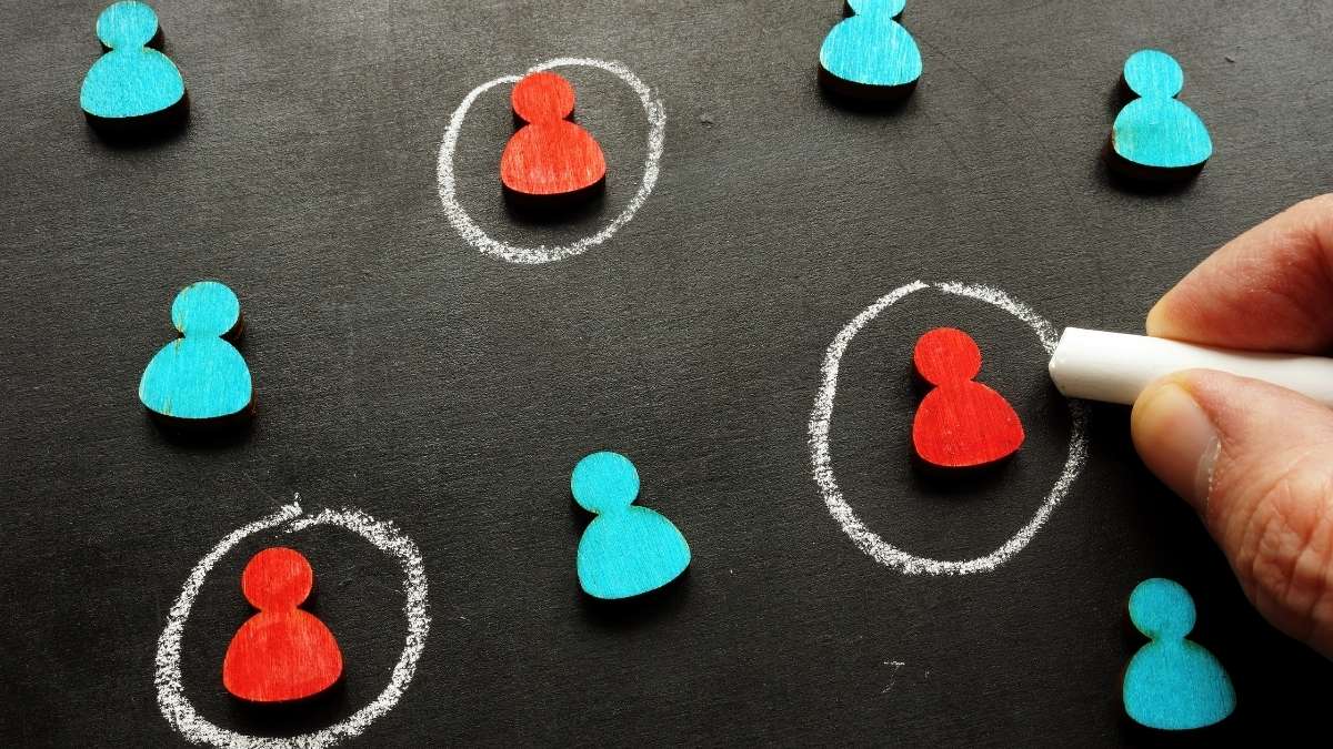 Chalk circles drawn around red figures on a blackboard, representing targeting your ideal client in niche marketing
